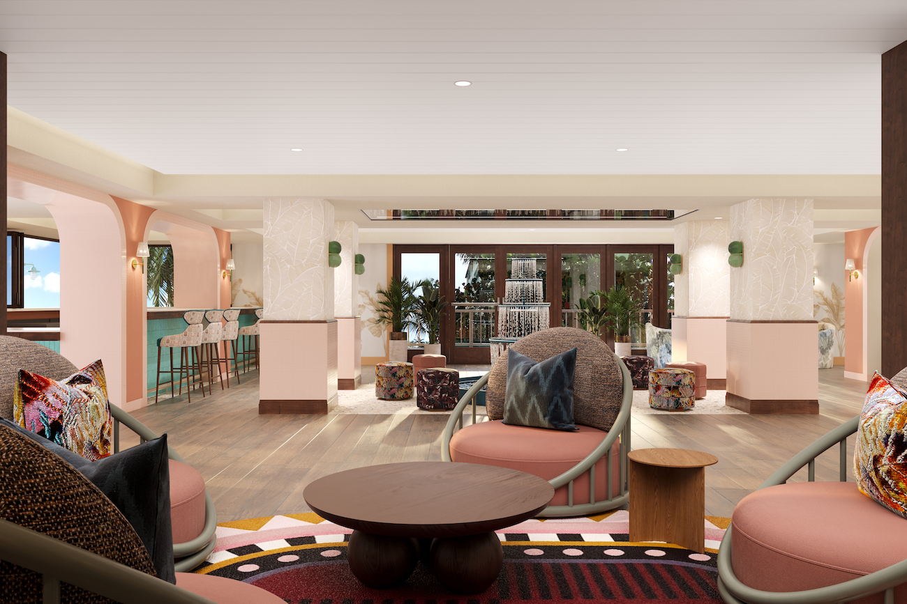 Modern hotel lounge with pastel walls, patterned rugs, round chairs, decorative pillows, and a bar area in the background. Large windows let in natural light.