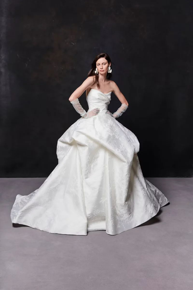A person wearing a white, strapless ball gown with a full skirt and matching opera-length gloves.