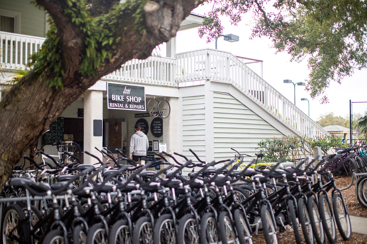 A row of rental bicycles parked in front of a bike shop.