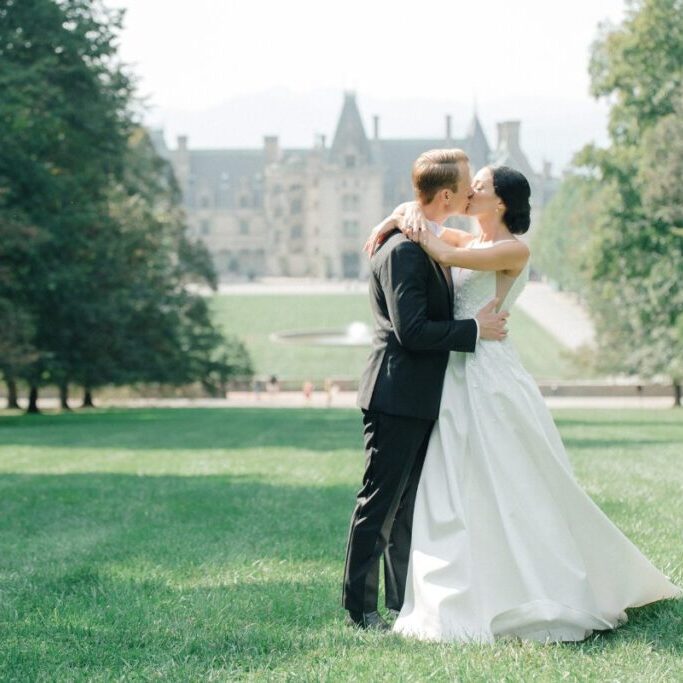 bride and groom kiss on lawn of Biltmore Asheville
