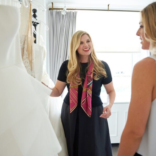 a bridal stylist shows a future bride some potential options at a bridal salon