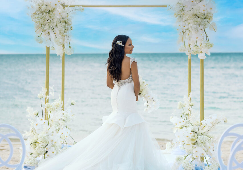 bride with white florals on beach