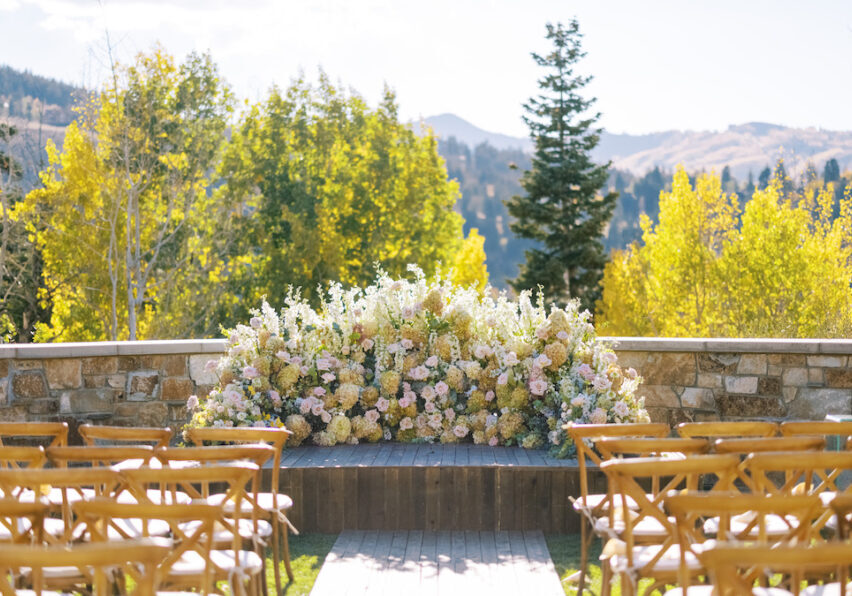 wedding ceremony setup with mountains in back and pink and yellow ground "altar" florals