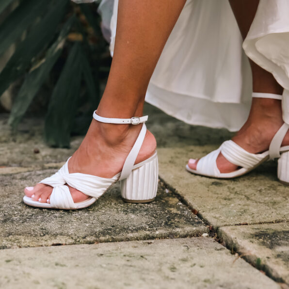woman stepping in white heels with pleated silk charmeuse bridal accessories